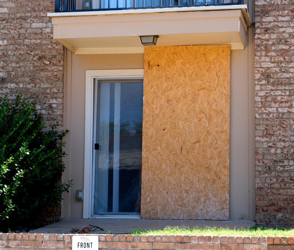 Some glass doors and windows are boarded up at The Alora.