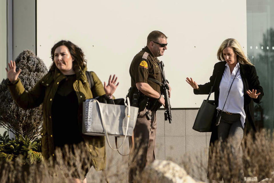 People evacuate with their hands aloft after a shooting at the Fashion Place mall in Murray, Utah, Sunday, Jan. 13, 2019. (Trent Nelson/The Salt Lake Tribune via AP)