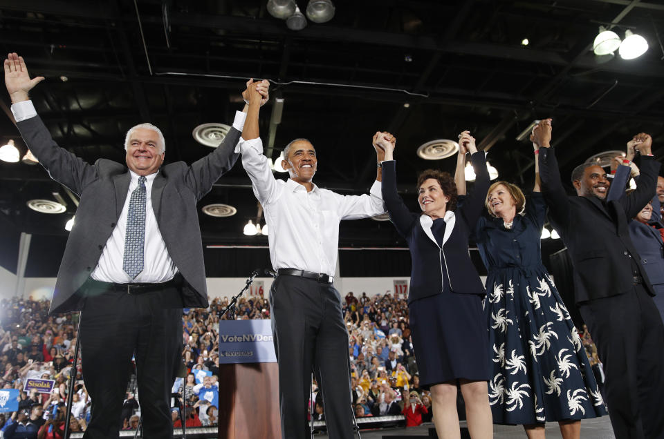 Former President Barack Obama, second from left, cheers at a rally in support of Clark County Commission Chair and Democratic gubernatorial candidate Steve Sisolak, left, candidate for Senate Jacky Rosen, third from left, Susie Lee, Democratic candidate for Nevada's third congressional district, second from right, Steven Horsford, candidate for Nevada's fourth congressional district, right, and other Nevada Democrats, Monday, Oct. 22, 2018, in Las Vegas. (AP Photo/John Locher)