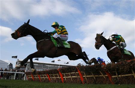 Jockey Barry Geraghty riding Jezki (L) clears the final fence ahead of jockey Tony McCoy (R) on My Tent Or Yours on the way to winning the Champion Hurdle Challenge Trophy at the Cheltenham Festival horse racing meet in Gloucestershire, western England March 11, 2014. REUTERS/Eddie Keogh