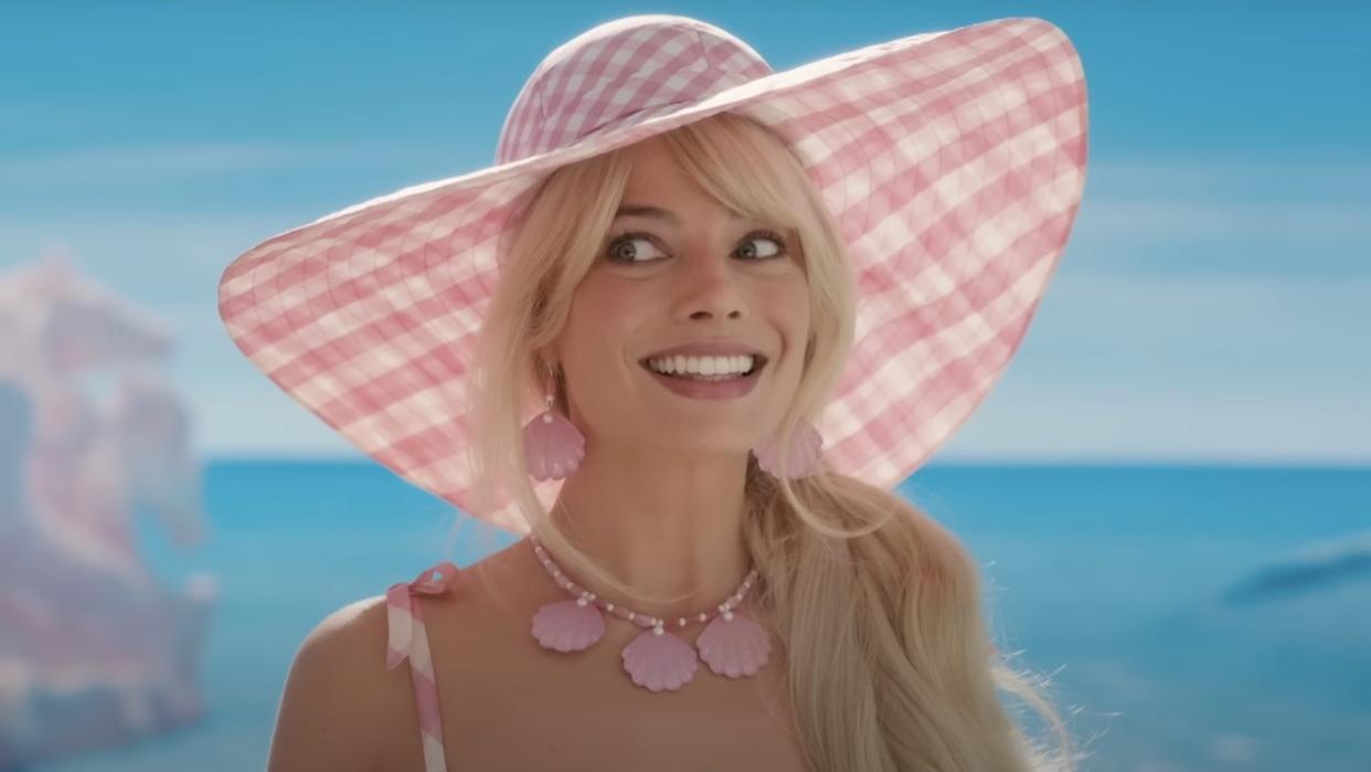  Margot Robbie's Barbie smiling on beach. 