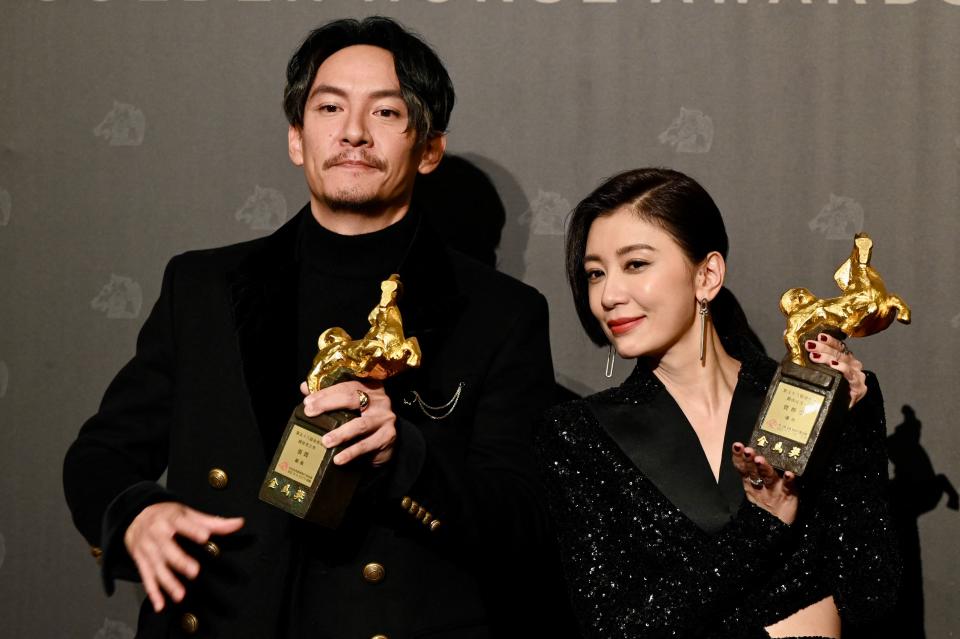 Taiwanese actress Alyssa Chia and actor Chang Chen display pose for pictures with their trophies after winning the Best Actress and the Best Actor at the 58th Golden Horse Film Awards in Taipei on November 27, 2021. / AFP / Sam Yeh