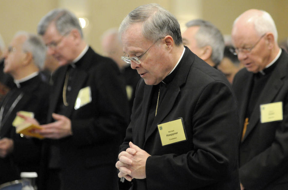 FILE - In this Nov. 10, 2008, Bishop Michael Hoeppner, center, of Crookston, Minn., prays during a semi-annual meeting of the United States Conference of Catholic Bishops in Baltimore. The Roman Catholic archbishop of St. Paul and Minneapolis says he has opened an investigation under a new Vatican protocol into allegations that the bishop of Crookston interfered with investigations into clerical sexual misconduct. Archbishop Bernard Hebda made the announcement Wednesday Sept. 11, 2019. His statement says the investigation targets Bishop Michael Hoeppner of the Crookston diocese in northwestern Minnesota. (AP Photo/ Steve Ruark,File)