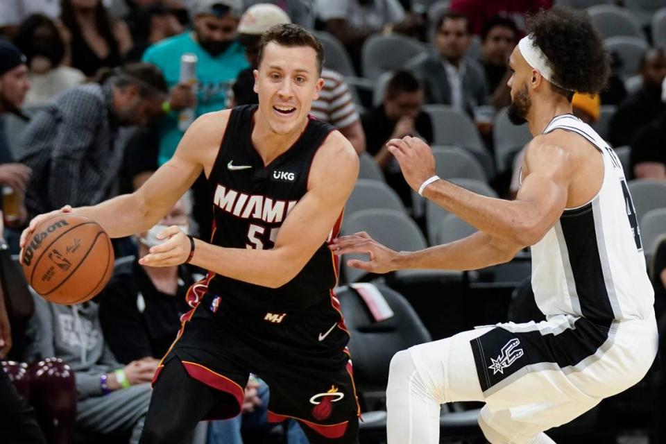 Miami Heat’s Duncan Robinson, left, drives against San Antonio Spurs’ Derrick White during the first half of a preseason NBA basketball game, Friday, Oct. 8, 2021, in San Antonio.