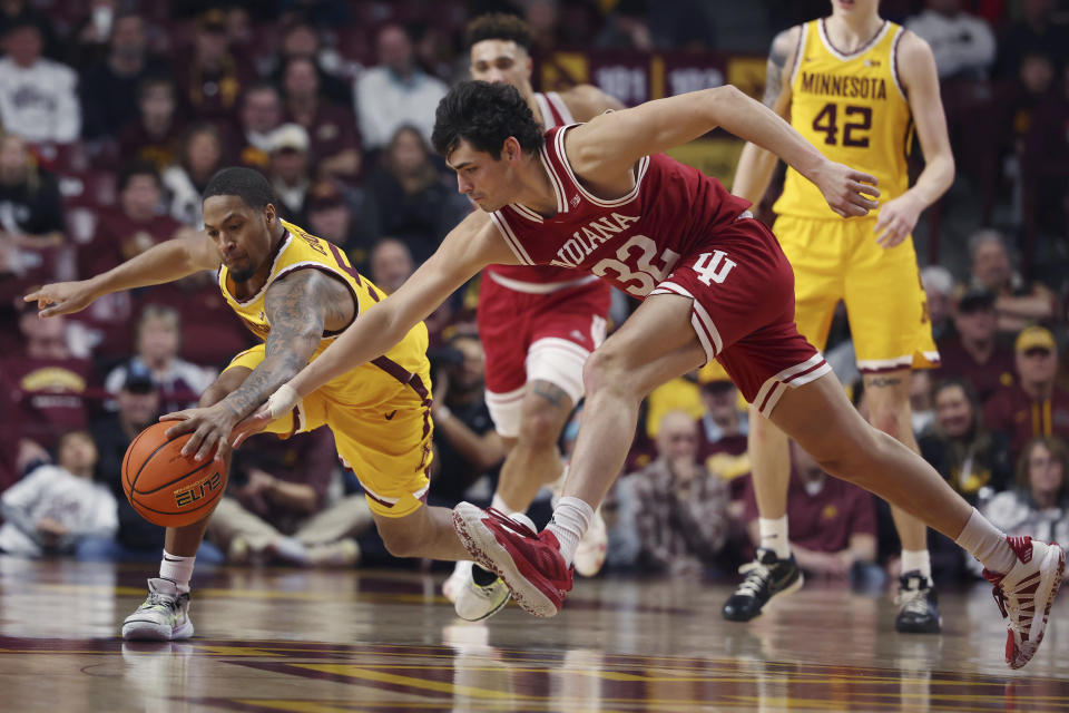 Indiana guard Trey Galloway (32) and Minnesota guard Ta'lon Cooper (55) reach for the ball during the second half of an NCAA college basketball game Wednesday, Jan. 25, 2023, in Minneapolis. Indiana won 61-57. (AP Photo/Stacy Bengs)