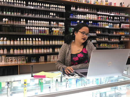 Rizza Colon works at the shop Cloud99 Vapes in Manhattan borough, New York, U.S. September 20, 2018. REUTERS/Melissa Fares