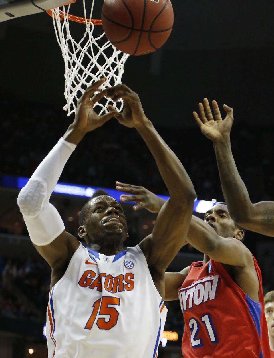Florida forward Will Yeguete (15) and Dayton forward Dyshawn Pierre (21) vie for a rebound during the first half in a regional final game at the NCAA college basketball tournament, Saturday, March 29, 2014, in Memphis, Tenn. (AP Photo/Mark Humphrey)