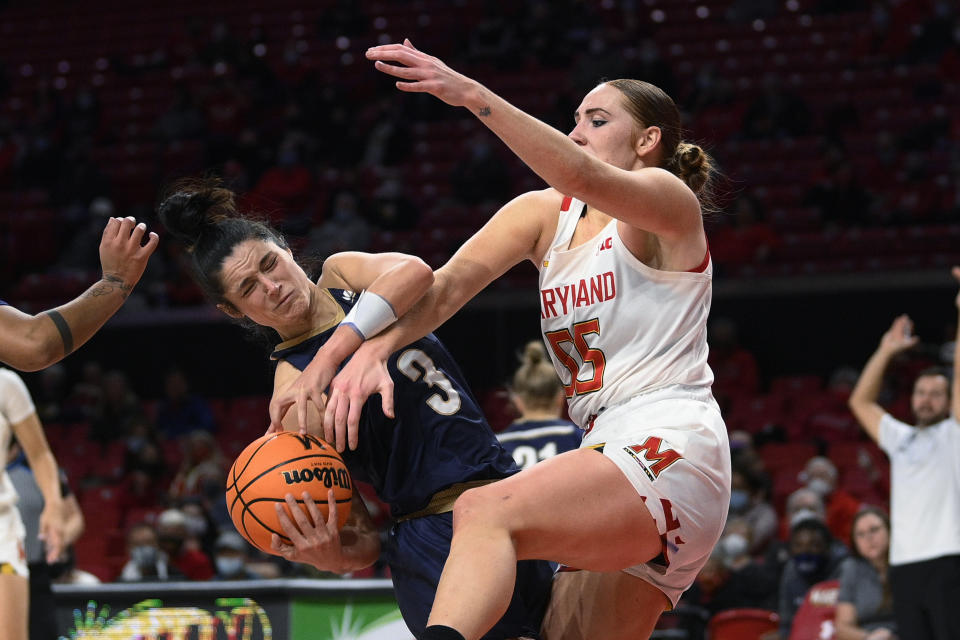 Maryland forward Chloe Bibby (55) and Mount St. Mary's guard Kendall Bresee (3) vie for the ball during the first half of an NCAA college basketball game Tuesday, Nov. 16, 2021, in College Park, Md. (AP Photo/Nick Wass)