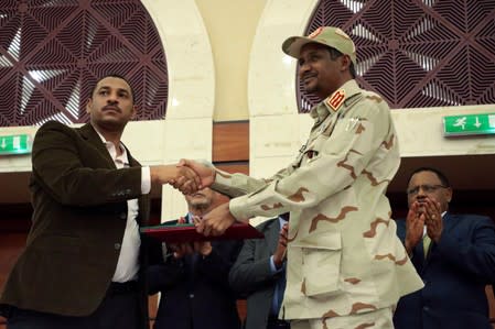 Deputy Head of Sudanese Transitional Military Council, Mohamed Hamdan Dagalo and opposition alliance signed coalition's leader Ahmad al-Rabiah shake hands after signing a political accord in Khartoum