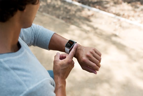 A man touching the crown on an Apple Watch.