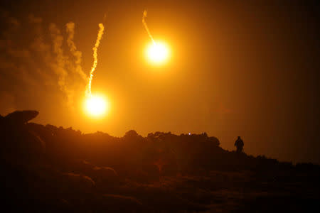 FILE PHOTO: Flares are seen in the sky during fighting in the Islamic State's final enclave, in the village of Baghouz, Deir Al Zor province, Syria March 11, 2019. REUTERS/Rodi Said/File Photo