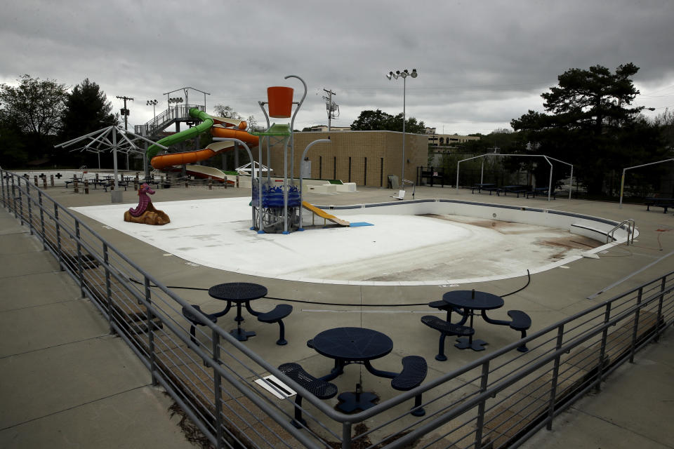 In this photo taken Friday, May 15, 2020, the public pool in Mission, Kan. is lifeless as plans remain in place to keep the pool closed for the summer to help prevent the spread of COVID-19. As warm weather approaches and many public pools remain closed there has been a surge of people using backyard pools as well at taking to water activities on lakes and rivers to get out and cool off. (AP Photo/Charlie Riedel)