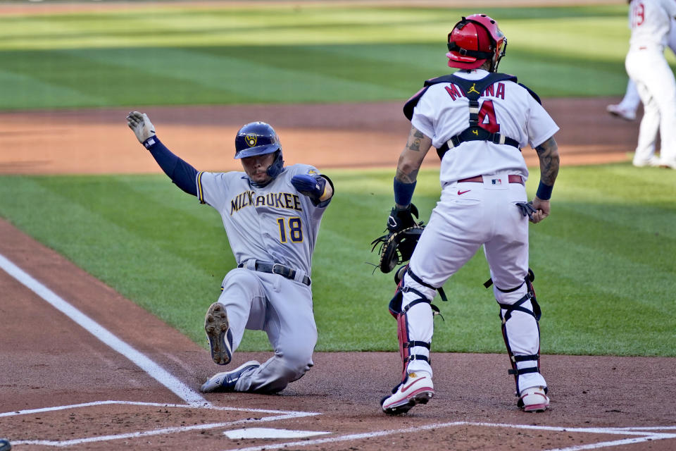 Milwaukee Brewers' Keston Hiura (18) scores past St. Louis Cardinals catcher Yadier Molina during the second inning in the first game of a baseball doubleheader Friday, Sept. 25, 2020, in St. Louis. (AP Photo/Jeff Roberson)