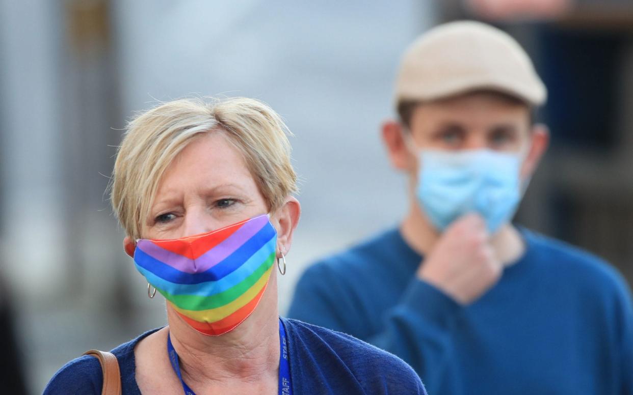 A woman wearing a face mask walks through the centre of Bradford, West Yorkshire - Danny Lawson /PA