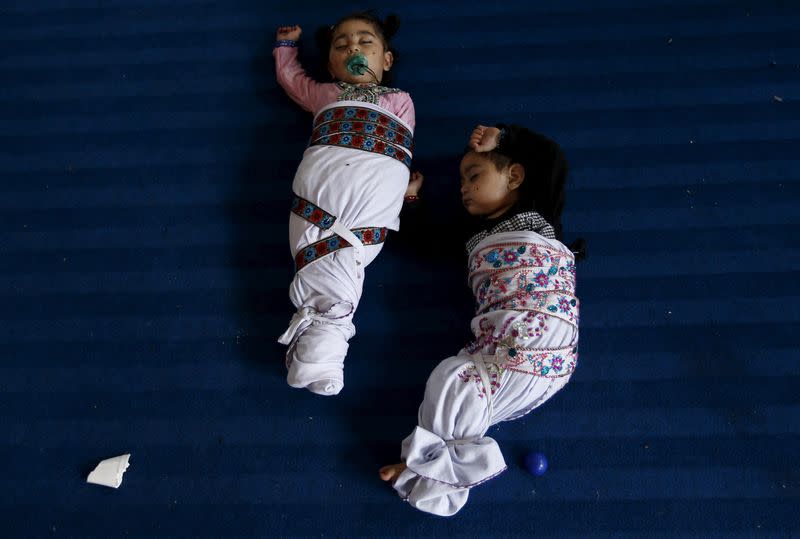 FILE PHOTO: Sikh twins sleep during the Baisakhi festival at Panja Sahib shrine in Hassan Abdel