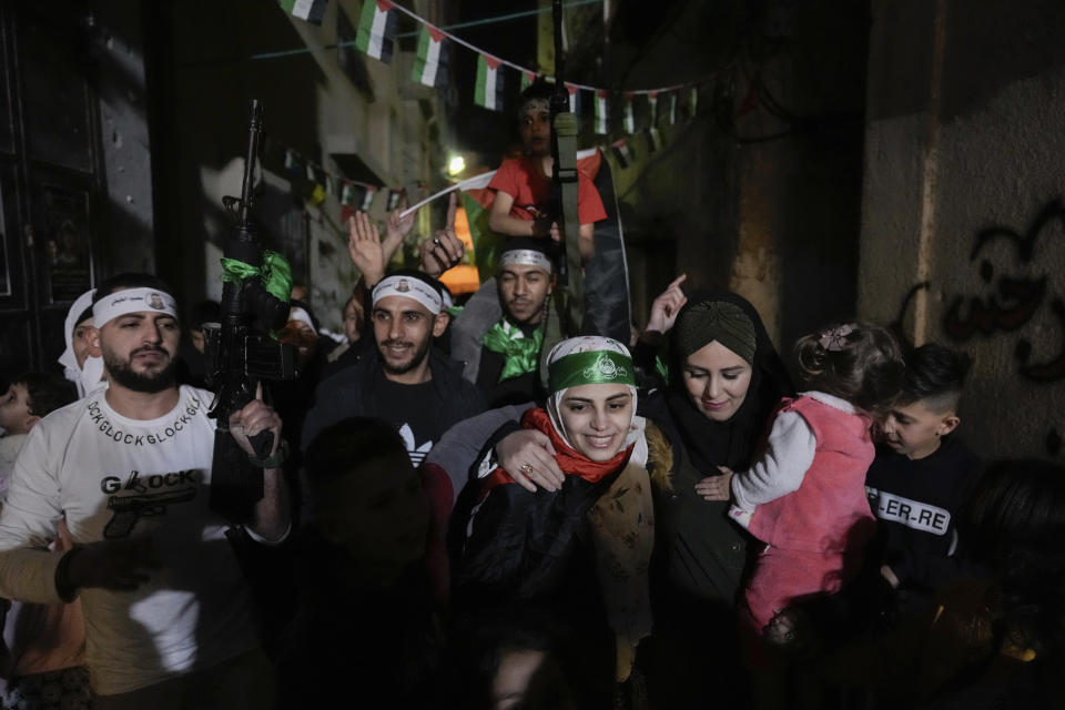 Aseel al-Titi, wearing a Hamas headband, a former Palestinian prisoner who was released by the Israeli authorities, is greeted by friends and family members in Balata, a Palestinian refugee camp in Nablus, West Bank, Friday, Nov. 24, 2023. The release came on the first day of a four-day cease-fire deal between Israel and Hamas during which the Gaza militants have pledged to release 50 hostages in exchange for 150 Palestinians imprisoned by Israel. (AP Photo/Majdi Mohammed)