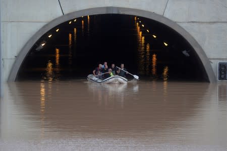 Rescue workers on a boat rescue a person stranded inside a flooded tunnel after heavy floods in Pilar de la Horadada