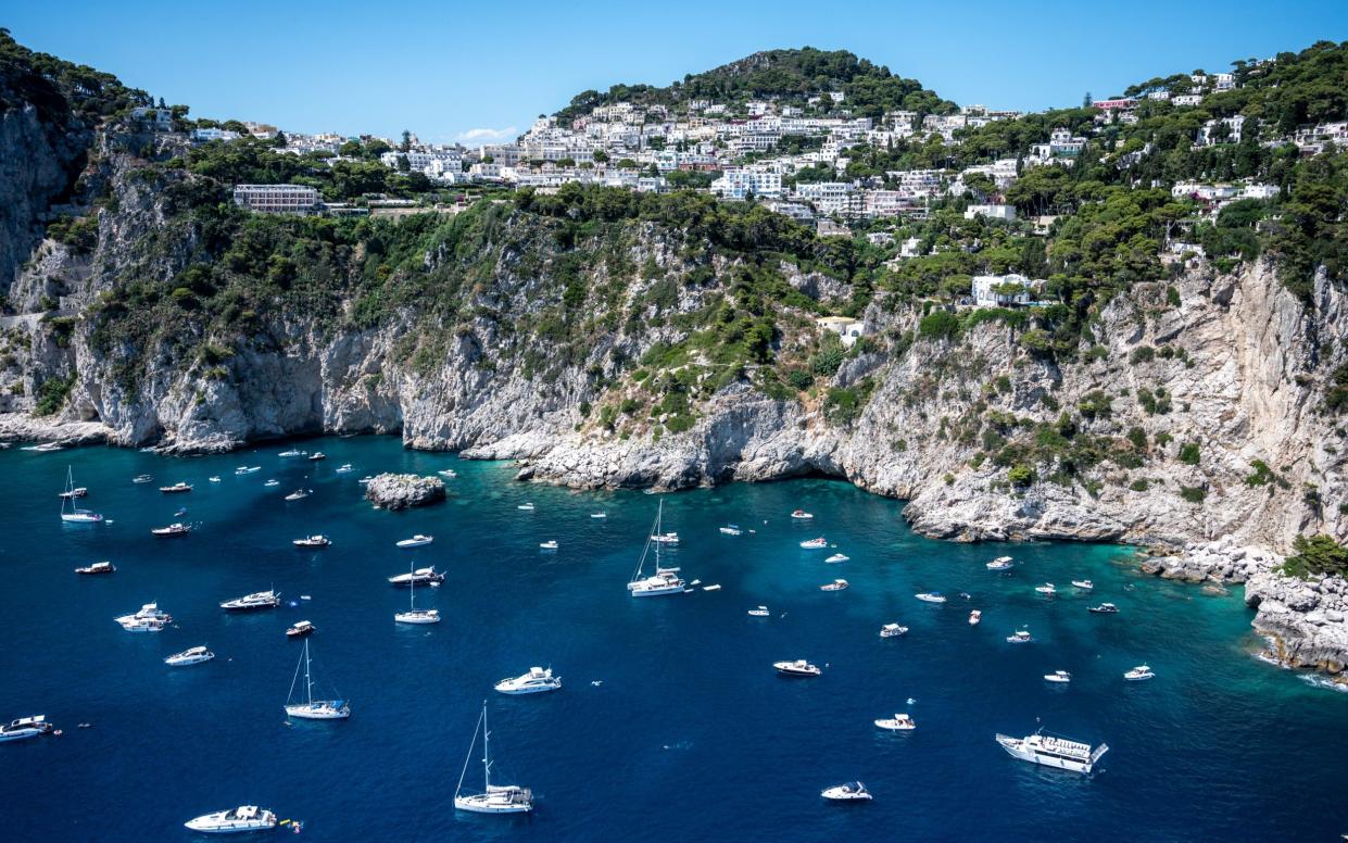 Capri's spectacular coastline, rich in inlets, with numerous yachts