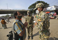 A man pleads with municipal officers as he is fined for not wearing a face mask in Bengaluru, India, Thursday, Oct. 29, 2020. India's confirmed coronavirus caseload surpassed 8 million on Thursday with daily infections dipping to the lowest level this week, as concerns grew over a major Hindu festival season and winter setting in. (AP Photo/Aijaz Rahi)