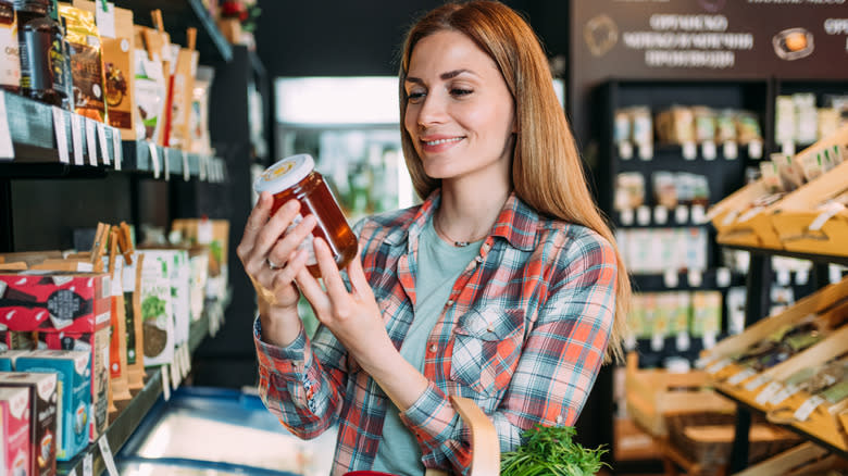 woman looking at honey jar