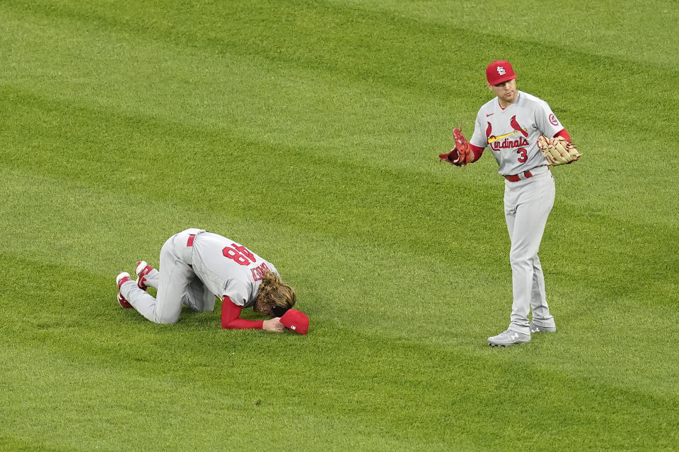 St. Louis Cardinals' Harrison Bader, left, stays on the ground as Dylan Carlson (3) signals the bench after Bader was unable to make a diving catch of a shallow fly ball by Chicago White Sox's Nick Madrigal during the third inning of an interleague baseball game Monday, May 24, 2021, in Chicago. (AP Photo/Charles Rex Arbogast)