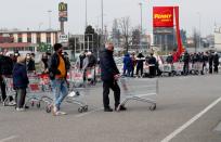 People queue at a supermarket outside the town of Casalpusterlengo