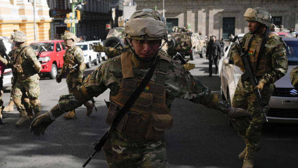 A soldier gestures for journalists to leave Plaza Murillo as soldiers gather outside the presidential palace in Plaza Murillo in La Paz, Bolivia, Wednesday, June 26, 2024. Bolivian President Luis Arce warned Wednesday that an “irregular” deployment of troops was taking place in the capital, raising concerns that a potential coup was underway. (AP Photo/Juan Karita)