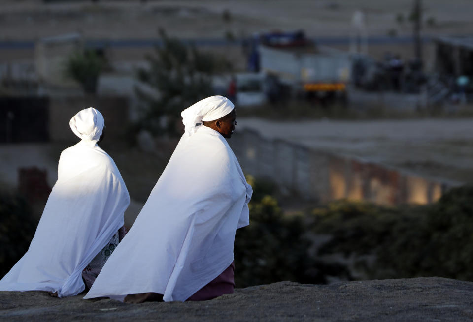 Zimbabweans sit and pray on top of a large rock on the outskirts of Harare, Zimbabwe, Sunday, Sept. 8, 2019. Former president Robert Mugabe, who enjoyed strong backing from Zimbabwe's people after taking over in 1980 but whose support waned following decades of repression, economic mismanagement and allegations of election-rigging, is expected to be buried next Sunday, state media reported. (AP Photo/Themba Hadebe)