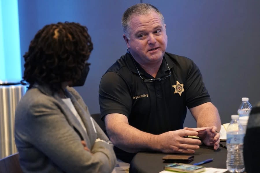 Rankin County Sheriff Bryan Bailey, right, speaks to an attendee at an employer engagement forum in Jackson, Miss., Nov. 4, 2021. (AP Photo/Rogelio V. Solis, File)