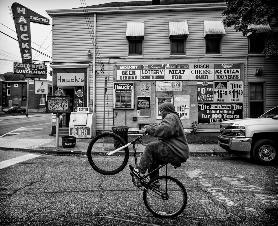 Cortez Hassel, 16, pops a wheelie on his bike on Hoertz Avenue, next to Hauck’s Handy Store. Oct. 19, 2018.