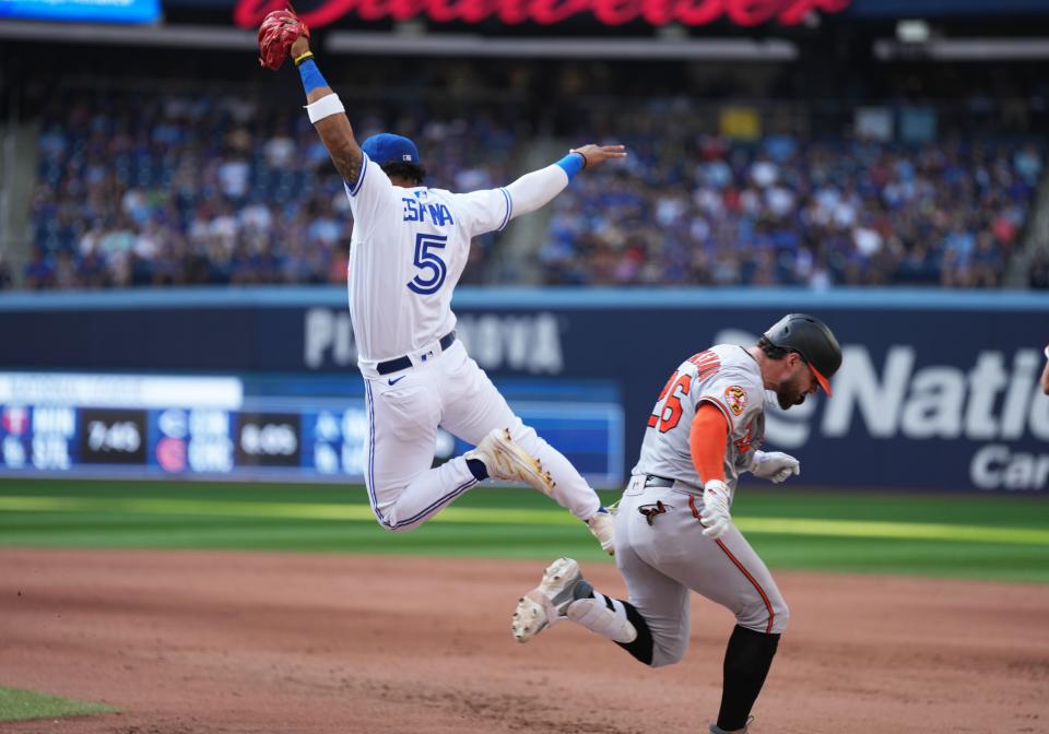 New Red Santiago Espinal, here making a catch of an errant throw at first base, learned about the team from Joey Votto, who he was teammates with for several weeks in the Toronto Blue Jays camp.