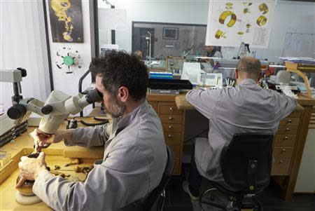 A gem setter (L) works next to a watchmaker at Buccellati workshop in Chiasso March 14, 2014. REUTERS/Denis Balibouse