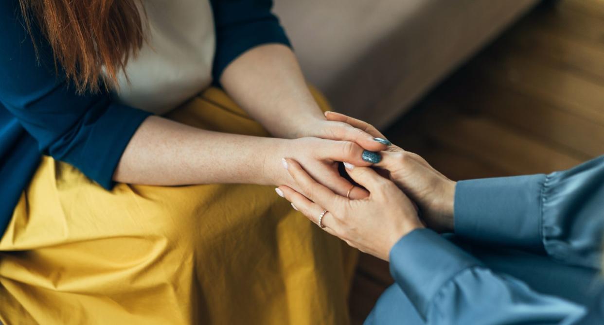 Two women holding hands in comfort as baby loss certificates introduced. (Getty Images)