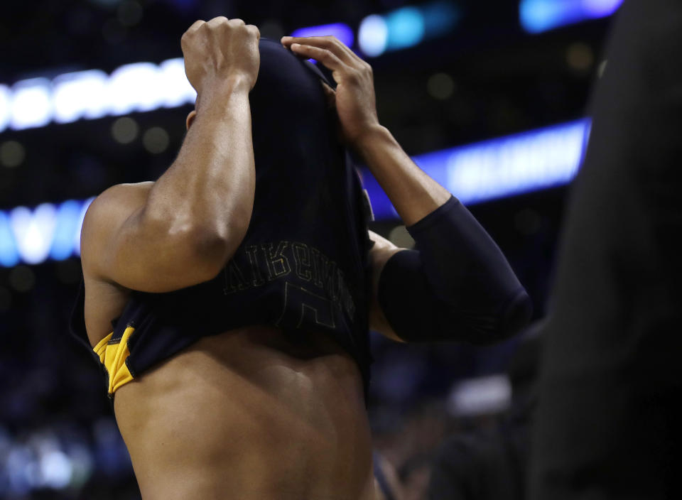 West Virginia’s Jevon Carter covers his eyes as he exits the floor following his last game as a Mountaineer. (AP Photo/Charles Krupa)