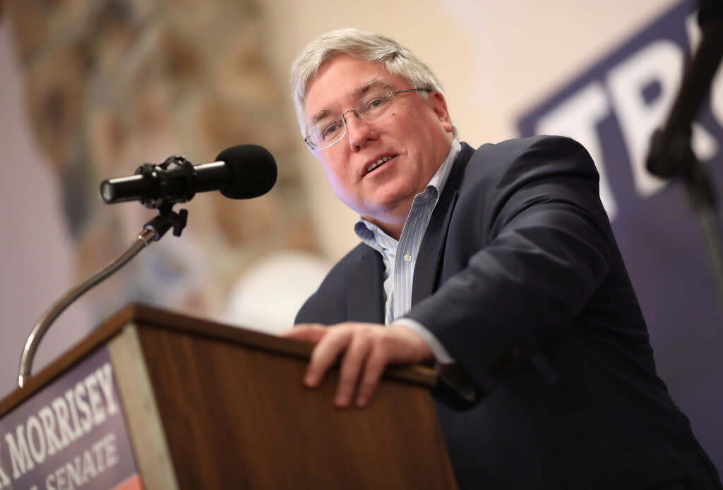 Patrick Morrisey stands at a podium with a microphone