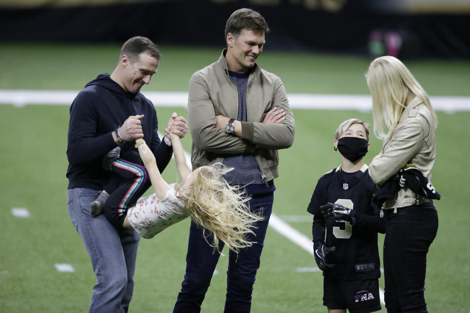 New Orleans Saints quarterback Drew Brees, left, plays with his children as Tampa Bay Buccaneers quarterback Tom Brady speaks with Brittany Brees after the Saints' loss. (AP Photo/Butch Dill)