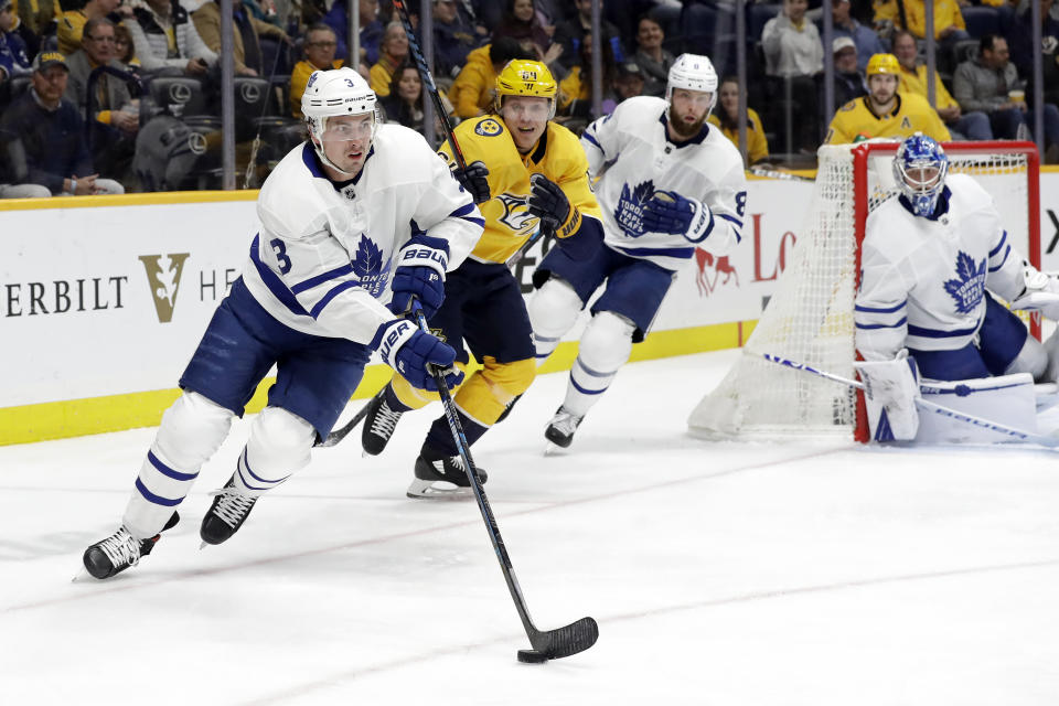 Toronto Maple Leafs defenseman Justin Holl (3) moves the puck ahead of Nashville Predators center Mikael Granlund (64), of Finland, in the second period of an NHL hockey game Monday, Jan. 27, 2020, in Nashville, Tenn. (AP Photo/Mark Humphrey)