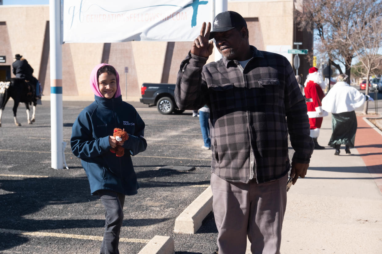 Tremaine Brown and his daughter Shilah await the arrival of the Panhandle Trail Riders on 6th Avenue at the 11th Annual Toy Drive Saturday morning in the historic Route 66 Amarillo District.