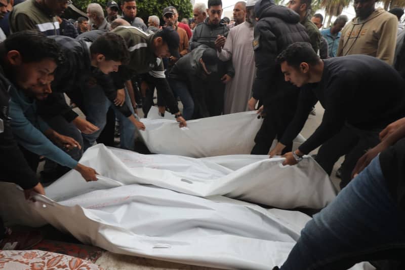 Relatives of the Palestinians killed in Israeli attacks, prepare the dead bodies, after receiving them from the morgue of Al-Aqsa Hospital, for burial in Dair El-Balah. Omar Ashtawy/APA Images via ZUMA Press Wire/dpa