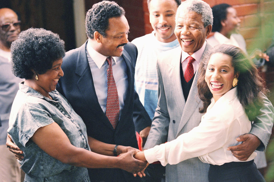 <p>Former U.S. presidential candidate Jesse Jackson, second from left, and Nelson Mandela, second from right, look on as their wives, Winnie Mandela, left, and Jacqueline Jackson hold hands when the Jacksons visited he Mandelas’ Soweto home in South Africa on Feb. 15, 1990. Mandela was released from prison on Feb. 2, 1990, after serving over 27 years. (Photo: Greg English/AP) </p>