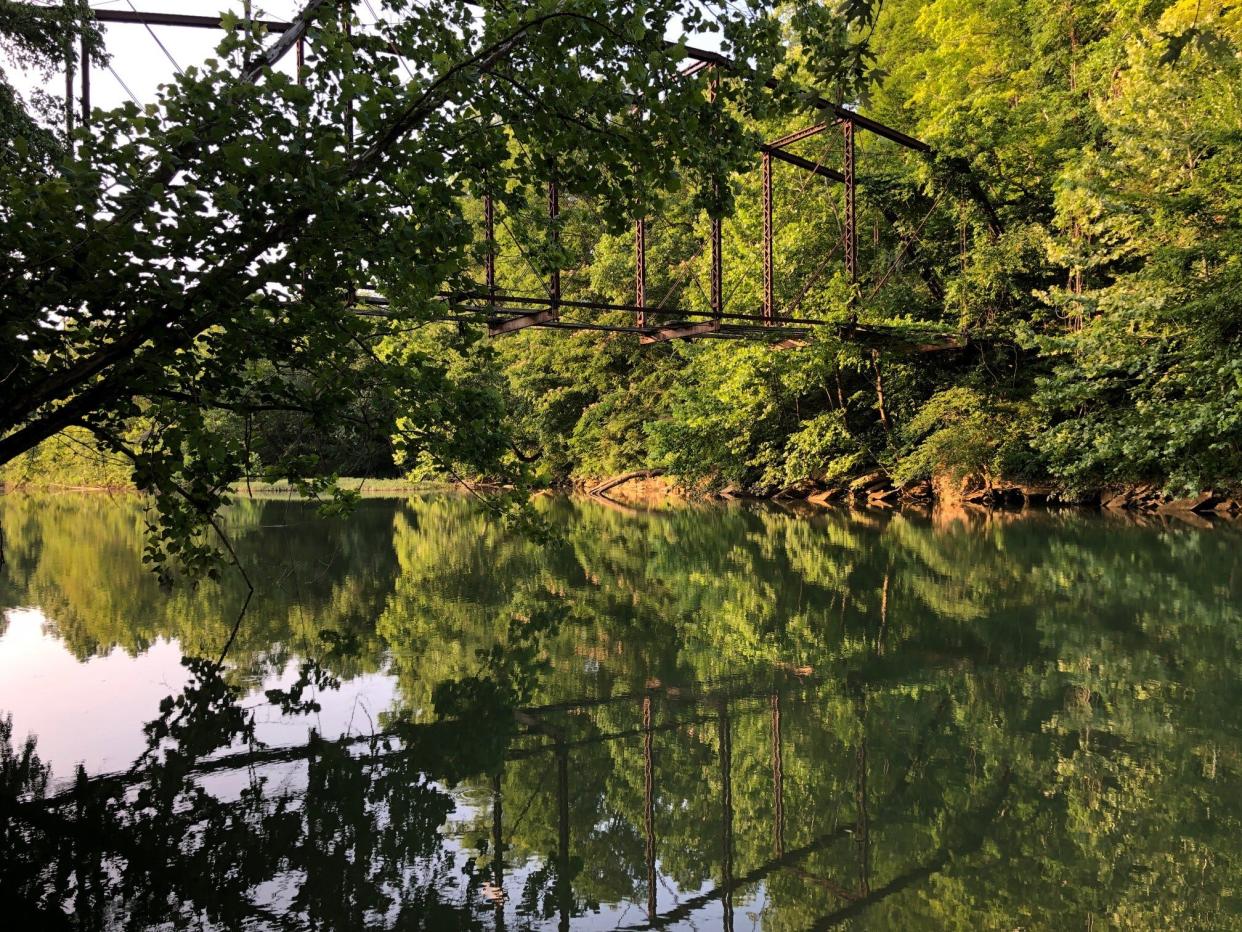This old, abandoned bridge reflects off of the water of the Buffalo River in Linden, Tenn.