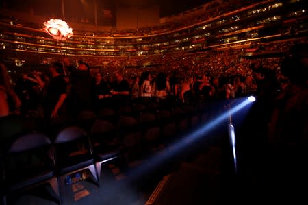 An usher uses a flashlight to clear the front row during an earthquake ahead of a concert by Shawn Mendes at Staples Center in Los Angeles