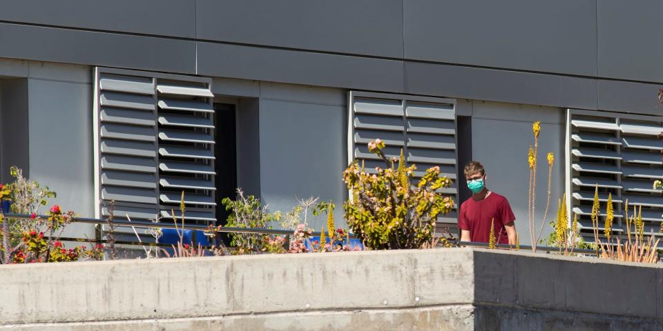 Person wearing surgical mask is seen on balcony at hospital in remote Spanish island of La Gomera coronavirus