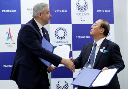 Etienne Thobois, Paris 2024 Director General, shakes hands with Toshiro Muto, Tokyo 2020 CEO, after signing documents during a ceremony marking conclusion of MoU between Tokyo 2020 and Paris 2024 Olympic Games in Tokyo, Japan, July 11, 2018. REUTERS/Kim Kyung-Hoon