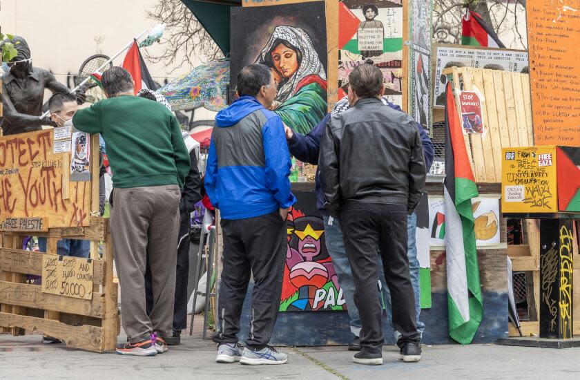 LOS ANGELES, CA - MAY 18: Richard Santillan, left; Raul Cardoza and Monte Perez speak with members of the Gaza solidarity encampment at California State University, Los Angeles on Saturday, May 18, 2024. In 1969, they were involved in the Chicano students encampment at the same location on campus. (Myung J. Chun / Los Angeles Times)