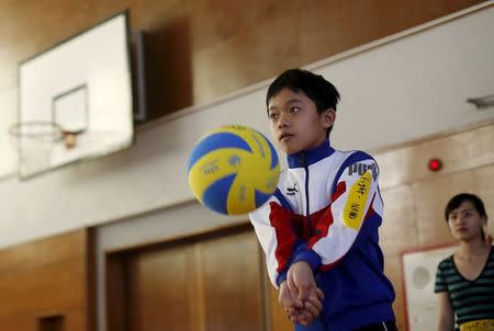 Kazuaki Hayama, a 13-year-old Japanese-born Vietnam boy named Nang, practices volleyball during Asia Sports Festa in Yokohama, south of Tokyo, Japan, October 25, 2015. Picture taken October 25, 2015. REUTERS/Yuya Shino