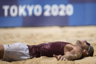 Edgars Tocs, of Latvia, lies in the sand as he celebrates winning a men's beach volleyball quarterfinal match against Brazil at the 2020 Summer Olympics, Wednesday, Aug. 4, 2021, in Tokyo, Japan. (AP Photo/Felipe Dana)