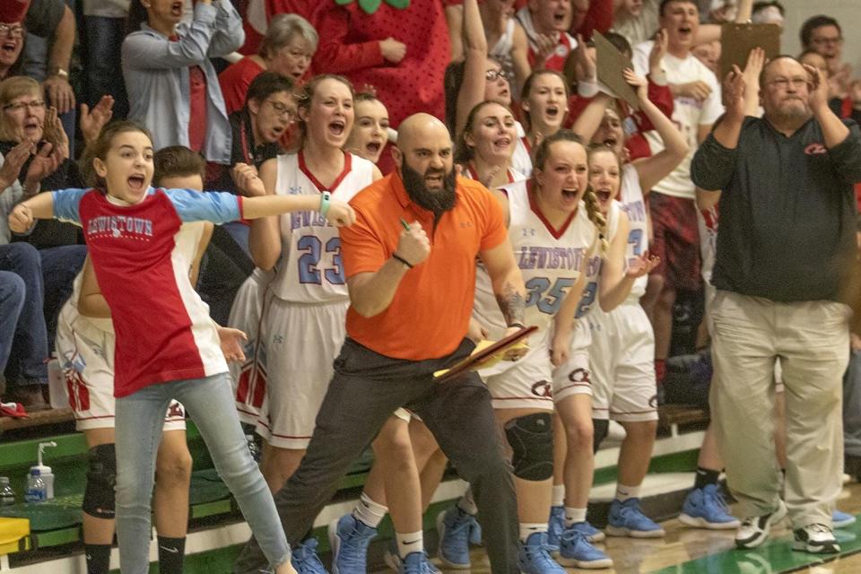 Joley McLaughlin (far left), Lewistown assistant coach Joey McLaughlin (center) and head coach Greg Bennett (far right) celebrate on the Lewistown bench during a game.