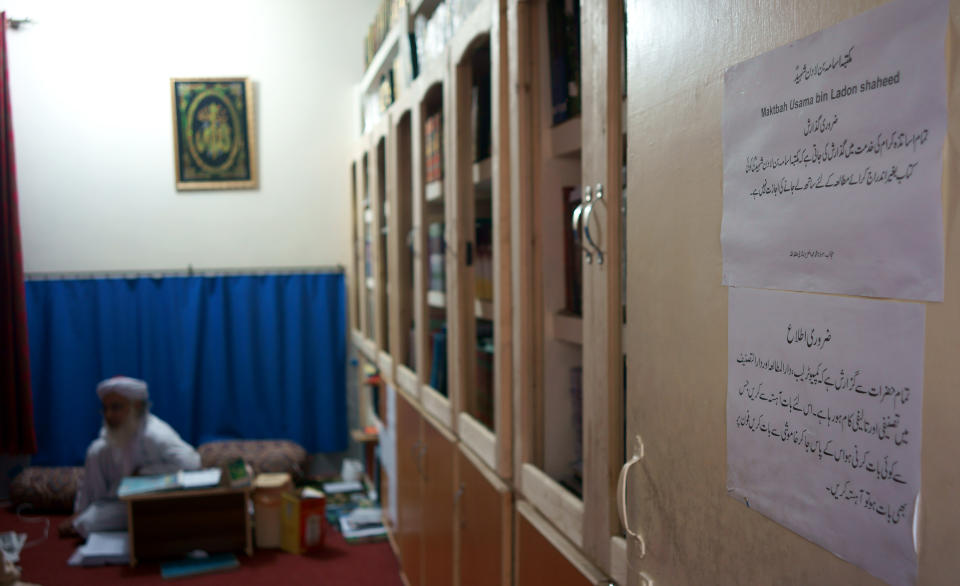 Maulana Abdul Aziz, head cleric of a Pakistani seminary, sits in a library named after slain al-Qaida leader Osama bin Laden, Friday, April 18, 2014 in Islamabad, Pakistan. A controversial Pakistani cleric who runs an Islamic seminary for girls in the capital of Islamabad has named the school's newly built library in honor of Osama bin Laden, his spokesman and a school administrator said Friday. Notices read instructions about library rules. (AP Photo/B.K. Bangash)