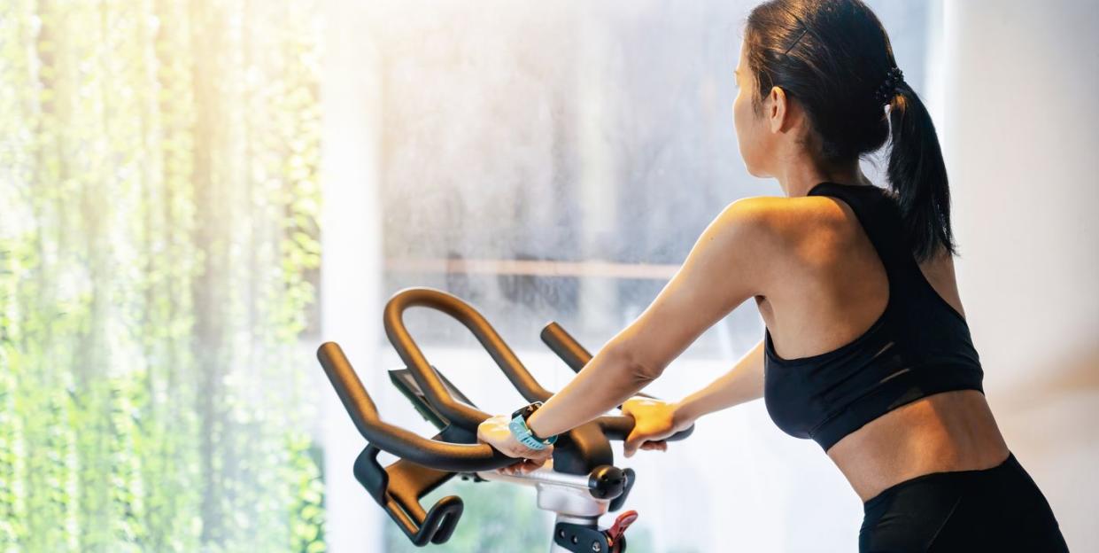 exercise bike cardio workout at fitness gym of woman taking weight loss with machine aerobic for slim and firm healthy in the morning fitness woman working out on exercise bike at the gym